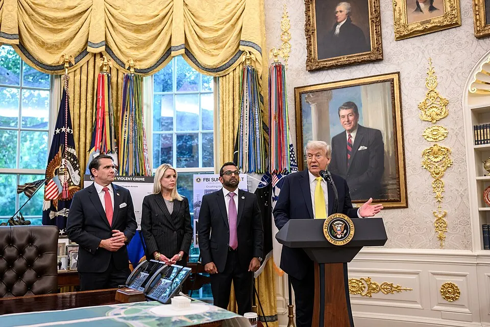 Donald Trump speaks at a podium in the White House with the presidential seal, alongside senior officials