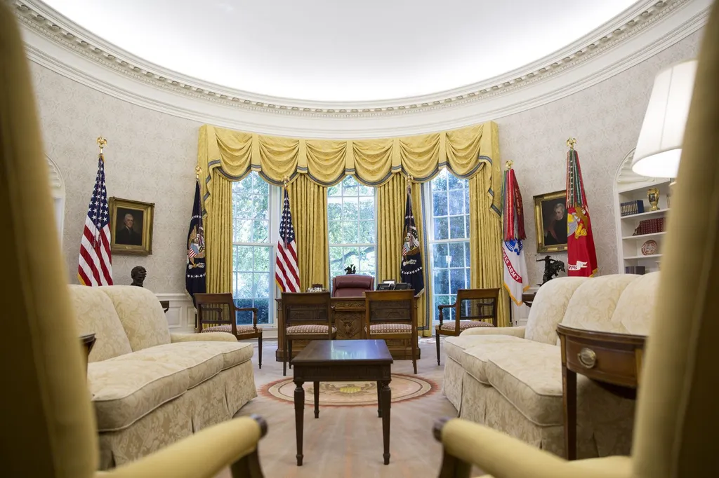 The Oval Office interior, with the Resolute desk, gold drapes and presidential seal rug, photographed in 2017