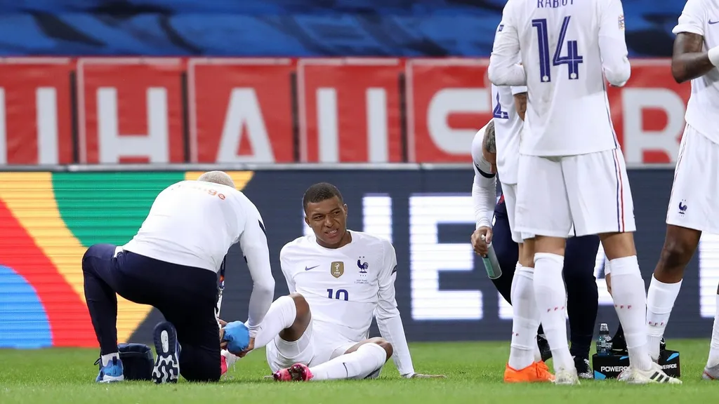 Kylian Mbappe receiving treatment on the pitch in a France kit