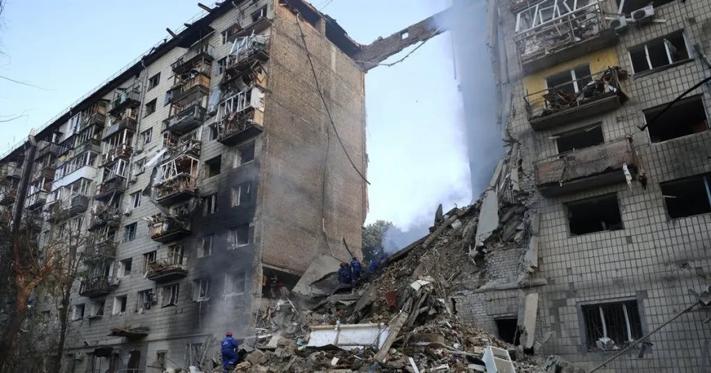 Apartment building in Kyiv heavily damaged by a Russian strike, rescue workers at the scene