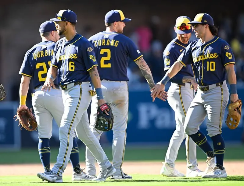 Milwaukee Brewers players including Brice Turang celebrate on the field after the NLDS Game 1 win