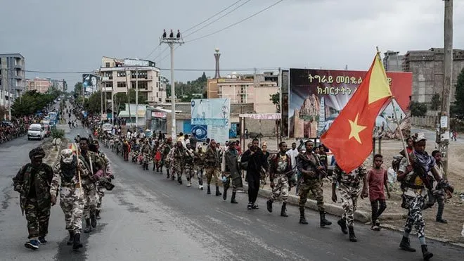 Armed Tigrayan fighters marching through a city street in Mekelle under the Tigray flag