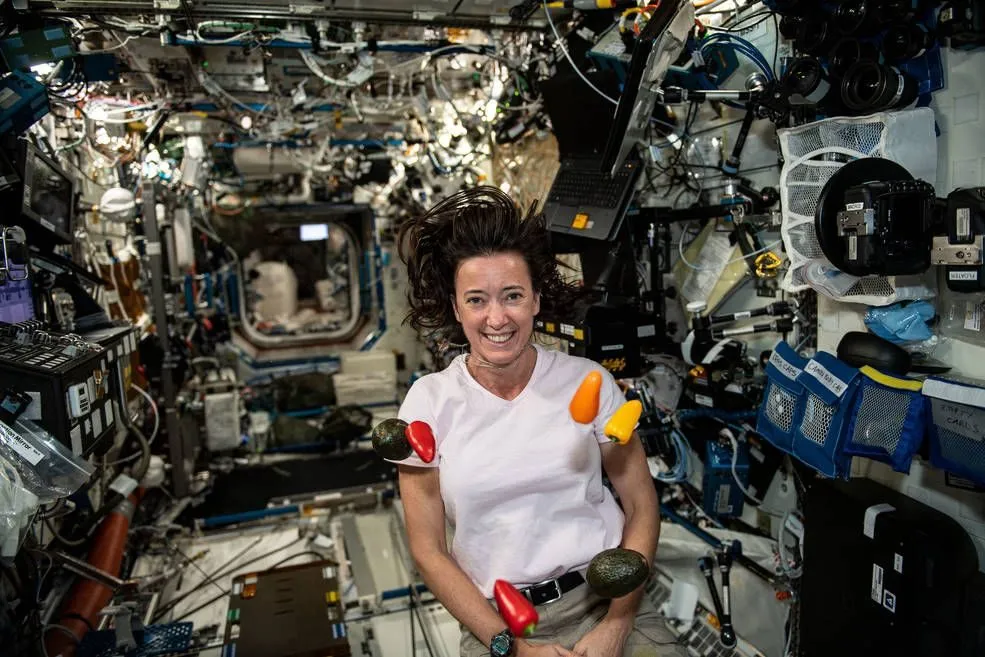 NASA astronaut Megan McArthur with floating vegetables aboard the International Space Station