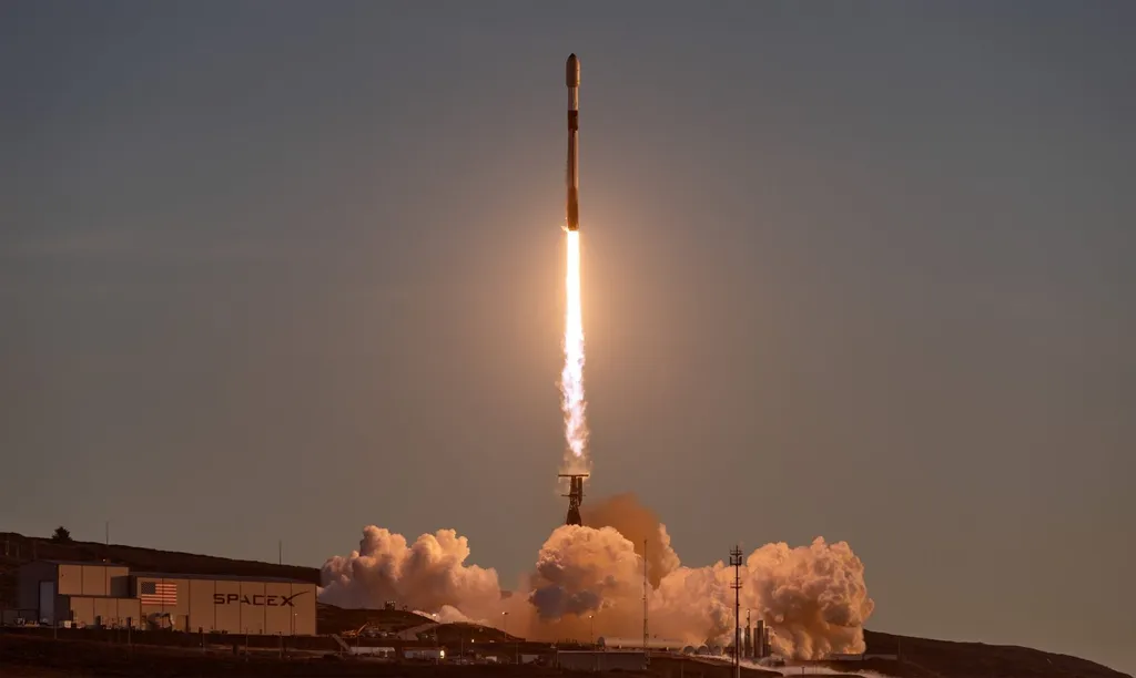 A SpaceX Falcon 9 rocket lifts off from Vandenberg at dusk carrying a satellite payload