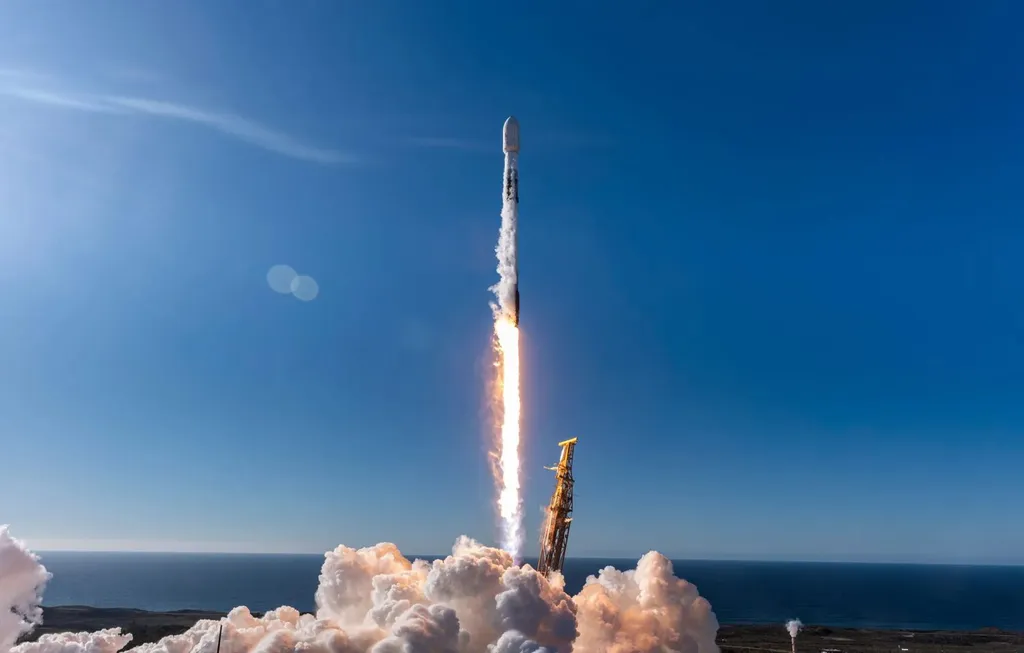 A SpaceX Falcon 9 rocket lifts off into a clear blue sky